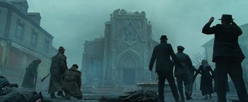 Movie still from “Wonder Woman” (2017), directed by Patty Jenkins – Two men are standing in front of an abandoned church; Extreme Wide shot, Low angle