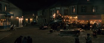 Movie still from “Wonder Woman” (2017), directed by Patty Jenkins – A group of people standing around a fountain at night; Extreme Wide shot, High angle