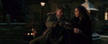 Movie still from “Wonder Woman” (2017), directed by Patty Jenkins – A man and a woman are drinking a drink together; Medium shot, Over the shoulder angle