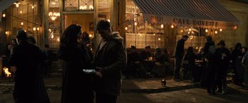 Movie still from “Wonder Woman” (2017), directed by Patty Jenkins – A group of people standing outside of a restaurant; Wide shot, Over the shoulder angle