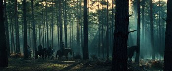 Movie still from “Wonder Woman” (2017), directed by Patty Jenkins – Two people riding horses through the woods at dusk; Extreme Wide shot, Low angle