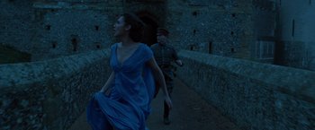 Movie still from “Wonder Woman” (2017), directed by Patty Jenkins – A woman in a blue dress and a man in a military uniform; Medium shot, Low angle