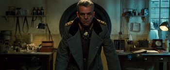 Movie still from “Wonder Woman” (2017), directed by Patty Jenkins – A man in a military uniform standing in front of a wall; Medium shot, Low angle