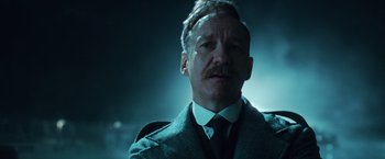 Movie still from “Wonder Woman” (2017), directed by Patty Jenkins – A person wearing a suit and tie; Close Up shot, Low angle