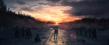 Movie still from “Wonder Woman” (2017), directed by Patty Jenkins – A woman standing in front of the sun setting; Extreme Wide shot, High angle