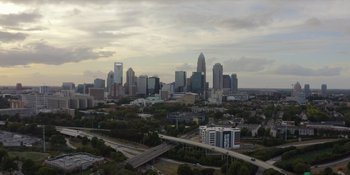 Movie still from “Woooooo! Becoming Ric Flair” (2022), directed by Ben Houser – A view of a city skyline from a distance; Extreme Wide shot, Low angle