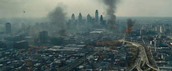Movie still from “World War Z” (2013), directed by Marc Forster – An aerial view of a city with smoke billowing out of it; Extreme Wide shot, High angle