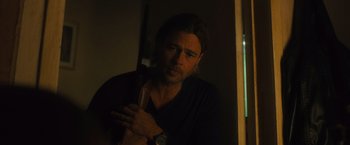 Movie still from “World War Z” (2013), directed by Marc Forster – A man with a beard is holding a watch in a dark room; Close Up shot, Over the shoulder angle