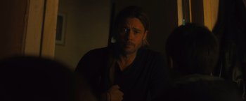 Movie still from “World War Z” (2013), directed by Marc Forster – A man holding a rifle in a dark room; Close Up shot, Over the shoulder angle