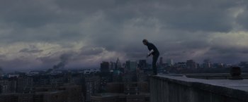 Movie still from “World War Z” (2013), directed by Marc Forster – A man standing on the edge of a building on a ledge; Extreme Wide shot, High angle