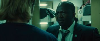 Movie still from “World War Z” (2013), directed by Marc Forster – A man wearing a suit and tie talking to another man in a suit; Close Up shot, Over the shoulder angle