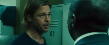 Movie still from “World War Z” (2013), directed by Marc Forster – A man standing in front of another man in front of a door; Close Up shot, Over the shoulder angle