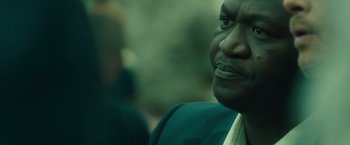 Movie still from “World War Z” (2013), directed by Marc Forster – A person wearing a suit and tie; Close Up shot, Over the shoulder angle