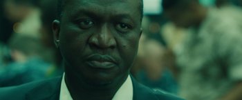 Movie still from “World War Z” (2013), directed by Marc Forster – A person wearing a suit and tie; Close Up shot, Over the shoulder angle