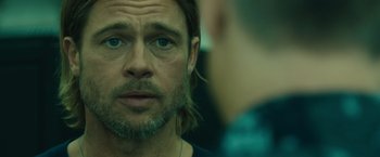 Movie still from “World War Z” (2013), directed by Marc Forster – A person with long hair and a beard; Close Up shot, Over the shoulder angle