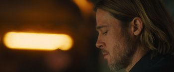 Movie still from “World War Z” (2013), directed by Marc Forster – A man's face with a blurry background; Close Up shot, Low angle