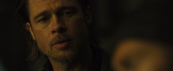 Movie still from “World War Z” (2013), directed by Marc Forster – A person with long hair and a beard; Close Up shot, Over the shoulder angle
