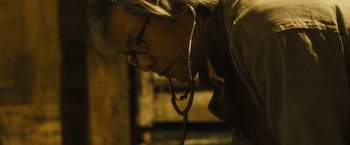 Movie still from “World War Z” (2013), directed by Marc Forster – An older woman wearing a stethoscope looking down; Close Up shot, Low angle