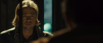 Movie still from “World War Z” (2013), directed by Marc Forster – A man sitting in front of a window with a microphone; Close Up shot, Over the shoulder angle