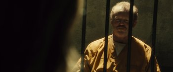 Movie still from “World War Z” (2013), directed by Marc Forster – An older man sitting in a jail cell; Close Up shot, Over the shoulder angle