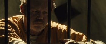 Movie still from “World War Z” (2013), directed by Marc Forster – A man in a yellow jacket behind bars; Close Up shot, Over the shoulder angle