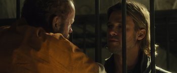 Movie still from “World War Z” (2013), directed by Marc Forster – Two men are in a jail cell looking at each other; Close Up shot, Over the shoulder angle