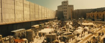 Movie still from “World War Z” (2013), directed by Marc Forster – A large group of people are gathered in a parking lot; Extreme Wide shot, High angle