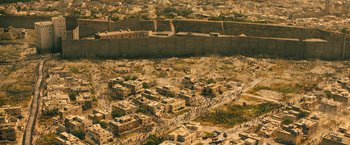 Movie still from “World War Z” (2013), directed by Marc Forster – An aerial view of a city with a wall in the background; Extreme Wide shot, High angle