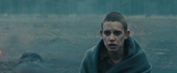 Movie still from “World War Z” (2013), directed by Marc Forster – A young man wrapped in a blanket looks at the camera; Close Up shot, Over the shoulder angle