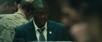 Movie still from “World War Z” (2013), directed by Marc Forster – A person wearing a suit and tie; Close Up shot, Over the shoulder angle