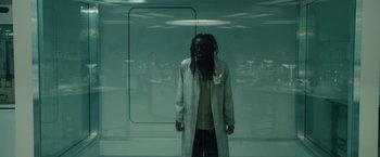 Movie still from “World War Z” (2013), directed by Marc Forster – A man with dreadlocks standing in front of a window; Medium shot, Low angle