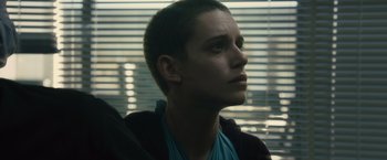 Movie still from “World War Z” (2013), directed by Marc Forster – A woman with short brown hair is looking out a window; Close Up shot, Low angle