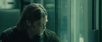 Movie still from “World War Z” (2013), directed by Marc Forster – A man with long hair sitting in front of a window; Close Up shot, Over the shoulder angle