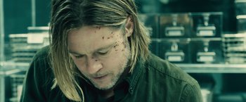 Movie still from “World War Z” (2013), directed by Marc Forster – A person wearing a green shirt; Close Up shot, Overhead angle