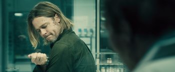 Movie still from “World War Z” (2013), directed by Marc Forster – A person with long hair and a beard; Close Up shot, Over the shoulder angle