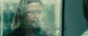 Movie still from “World War Z” (2013), directed by Marc Forster – A person with long hair and a beard; Close Up shot, Over the shoulder angle