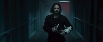 Movie still from “World War Z” (2013), directed by Marc Forster – A man holding a book in his hands; Medium shot, Low angle