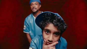 A man and a boy in blue baseball uniforms