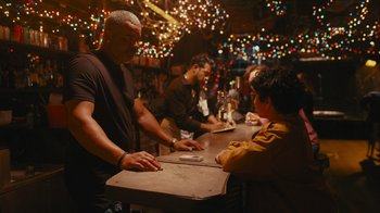 A group of people sitting at a table in a bar