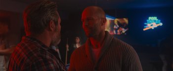 Movie still from “Wrath of Man” (2021), directed by Guy Ritchie – Two men are talking in front of a mirror; Close Up shot, Over the shoulder angle