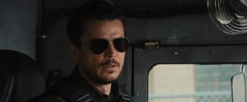 Movie still from “Wrath of Man” (2021), directed by Guy Ritchie – A person wearing sunglasses; Close Up shot, Over the shoulder angle