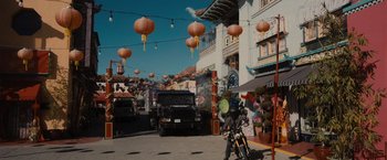 Movie still from “Wrath of Man” (2021), directed by Guy Ritchie – A street scene with a motorcycle parked on the side of the road; Extreme Wide shot, High angle