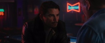 Movie still from “Wrath of Man” (2021), directed by Guy Ritchie – A person sitting in a room; Close Up shot, Over the shoulder angle