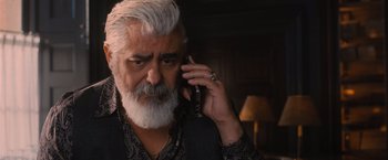 Movie still from “Wrath of Man” (2021), directed by Guy Ritchie – An older man talking on a cell phone while wearing a ring; Close Up shot, Low angle