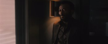 Movie still from “Wrath of Man” (2021), directed by Guy Ritchie – A man with a beard is looking at the camera; Close Up shot, Over the shoulder angle