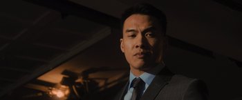 Movie still from “Wrath of Man” (2021), directed by Guy Ritchie – A person wearing a suit and tie; Close Up shot, Low angle