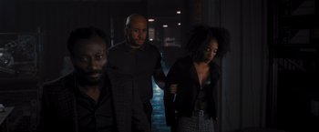 Movie still from “Wrath of Man” (2021), directed by Guy Ritchie – A group of people standing next to each other in a dark room; Medium shot, High angle