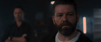 Movie still from “Wrath of Man” (2021), directed by Guy Ritchie – A person with a beard; Close Up shot, Over the shoulder angle