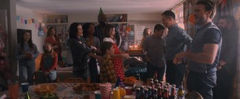 Movie still from “Wrath of Man” (2021), directed by Guy Ritchie – A group of people standing around a table with a cake on it; Wide shot, High angle