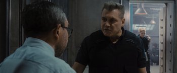 Movie still from “Wrath of Man” (2021), directed by Guy Ritchie – A man in black shirt talking to another man in black shirt; Close Up shot, Over the shoulder angle